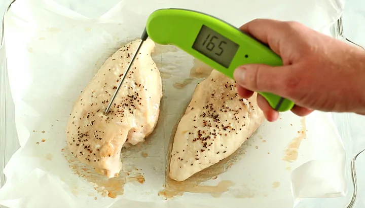 Checking baked chicken breast internal temp of 165 with a digital thermometer