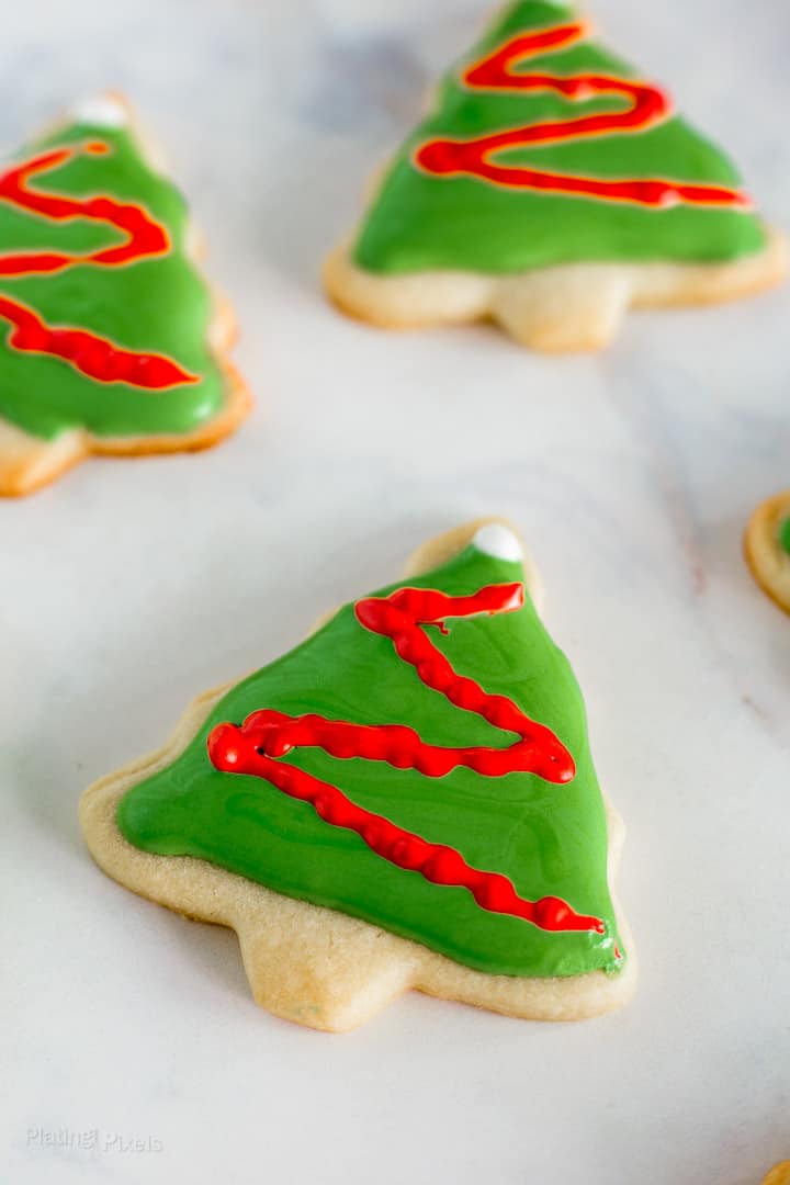 Close up of Decorated Christmas Tree Cookies with Royal Icing on a white background
