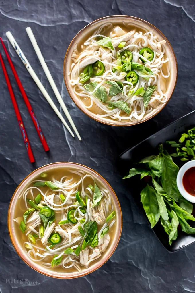Two bowls of Slow Cooker Chicken Pho Soup on table ready to eat