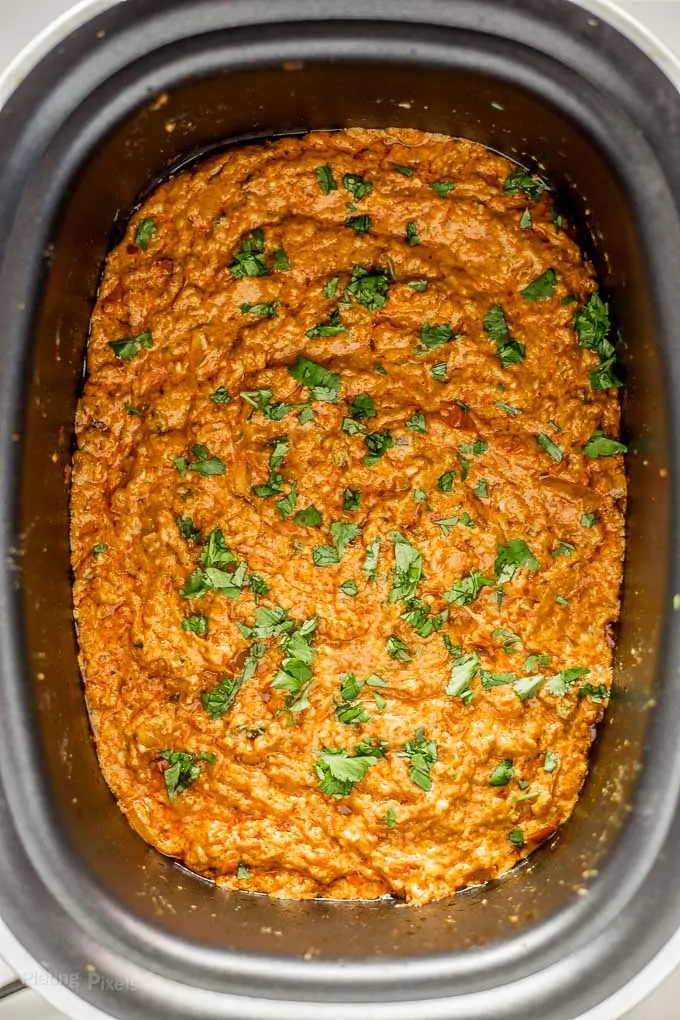 Chorizo Queso Dip in a slow cooker garnished with cilantro