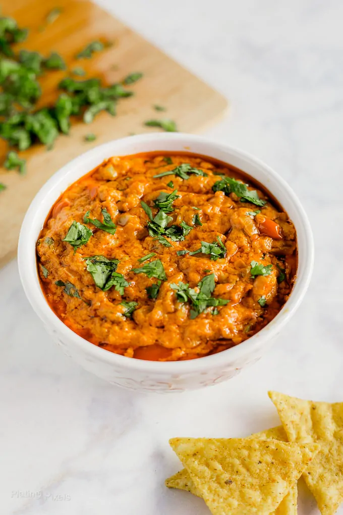 Slow Cooker Chorizo Queso Dip in a white bowl next to tortilla chips