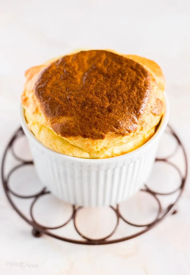 Angled shot of Easy Cheese Souffle with Brie Cheese sitting on cooling rack over white background