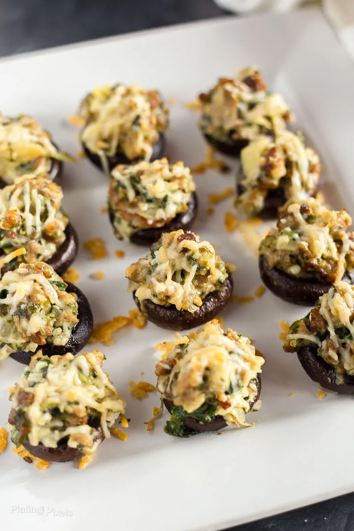 Angled shot of gluten-free Sausage Stuffed Mushrooms on a white plate ready to be served