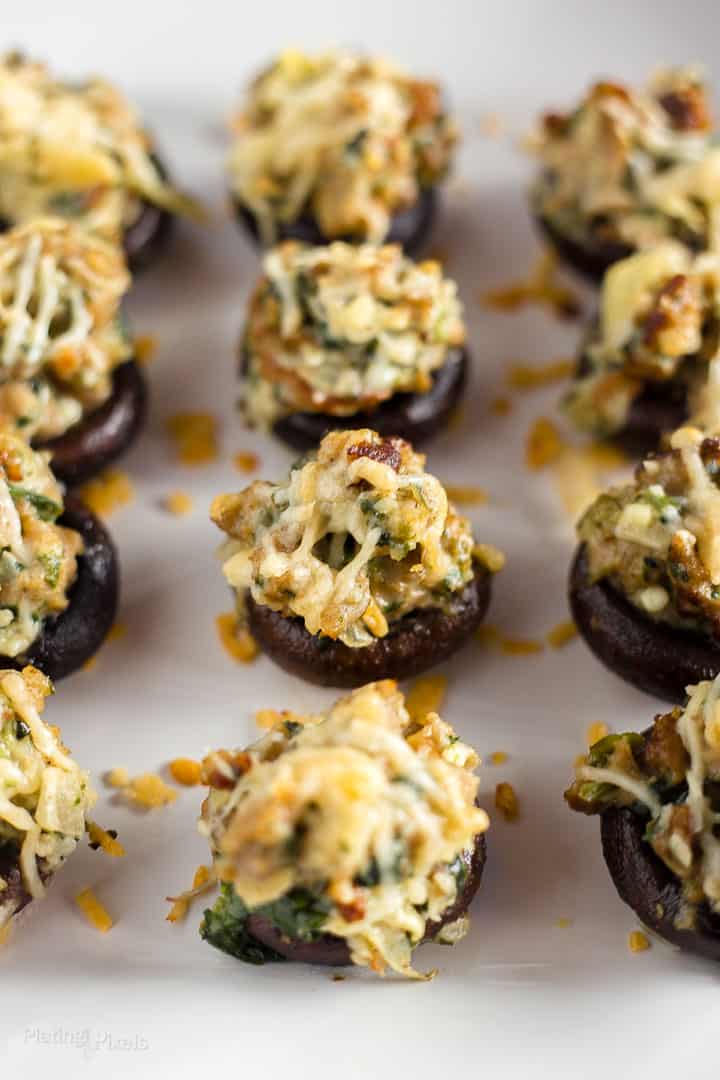 Close up shot of gluten-free Sausage Stuffed Mushrooms on a white plate ready to be served