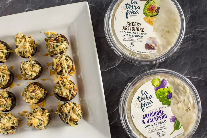 Sausage Stuffed Mushrooms on a plate next to two flavors of La Terra Fina dip