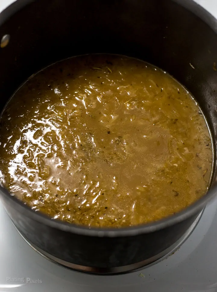 Process shot of pot of French Onion Soup simmering on the stove