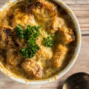 Overhead shot of French Onion Soup in a ramekin on a wooden table