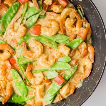 Coconut Curry Shrimp in a wok cooking with vegetables