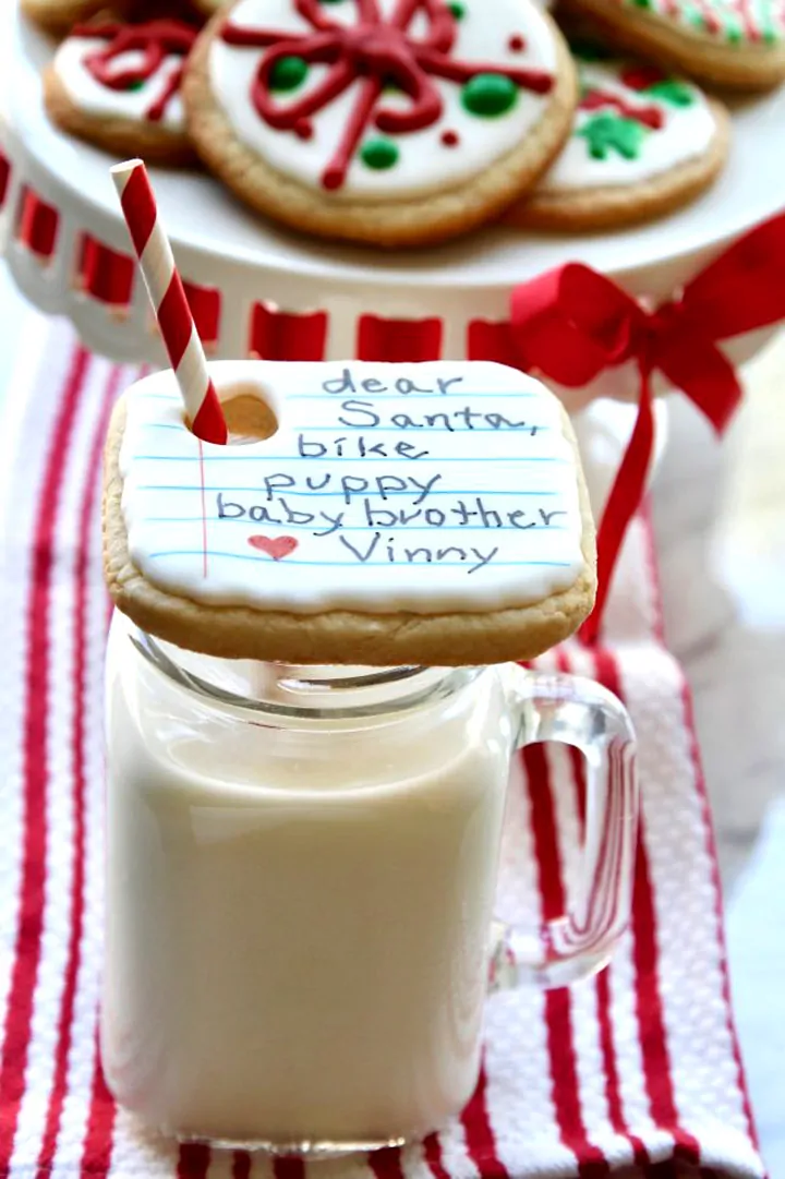 Iced decorated note to Santa Christmas cookie over a glass of milk