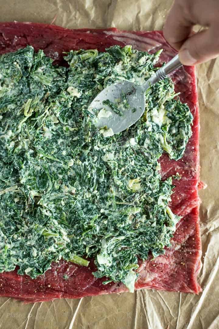 Spreading Creamy Spinach filling on flattened Flank Steak