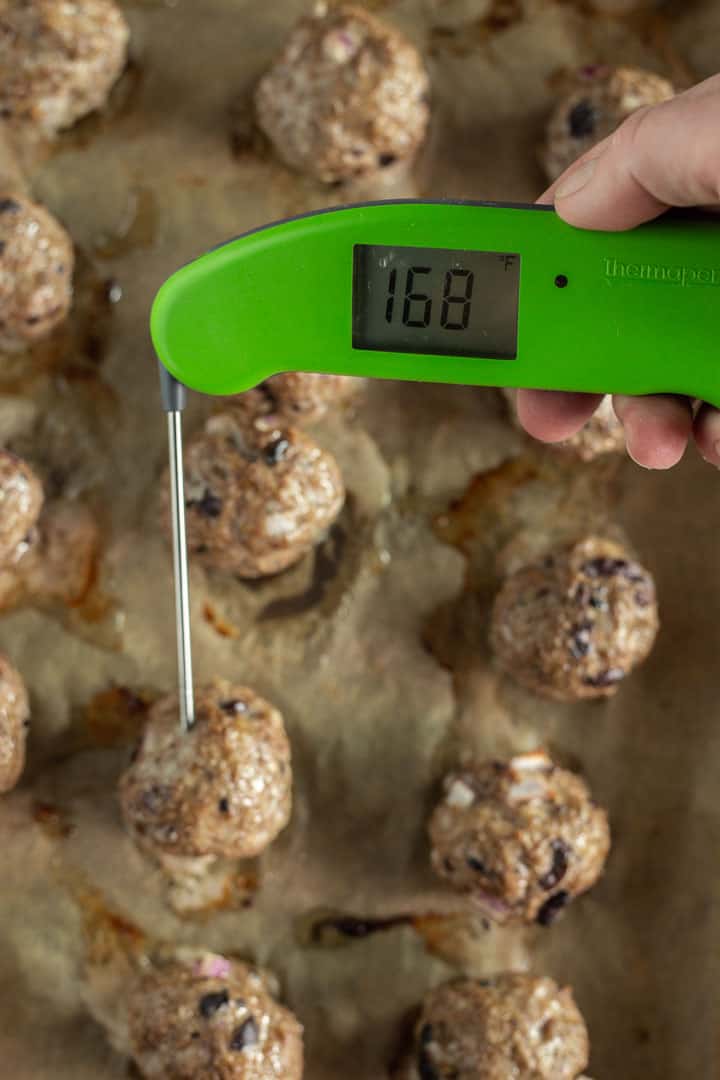 Checking internal temp of Greek Baked Meatballs with a digital thermometer