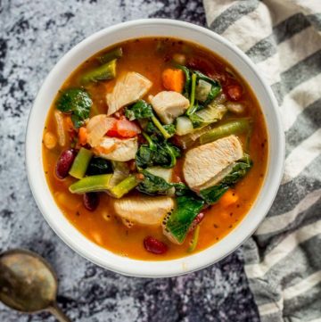 One Pot Chicken Minestrone in a white bowl on a dark marble table