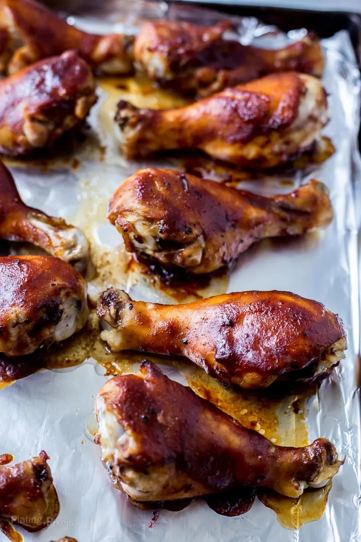 Close up of Honey BBQ Oven Baked Chicken Drumsticks on a baking sheet
