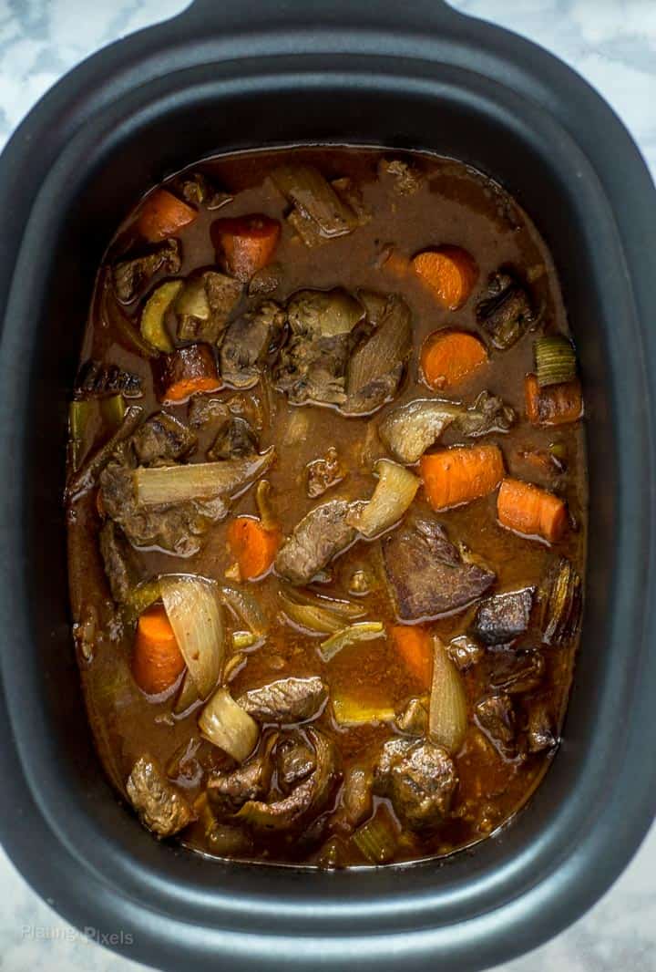 Process shot of just cooked Slow Cooker Beef Stew with root vegetables in a slow cooker