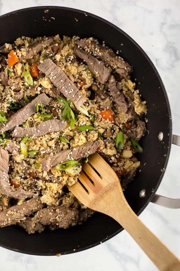 Process shot of cooking Keto Beef Fried Rice in a large wok