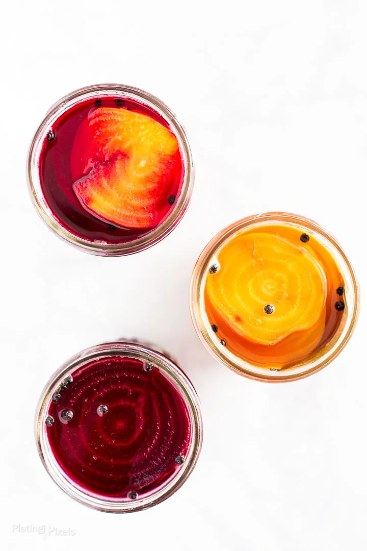 Overhead shot of three jars of red and yellow pickled beets to go in refrigerator