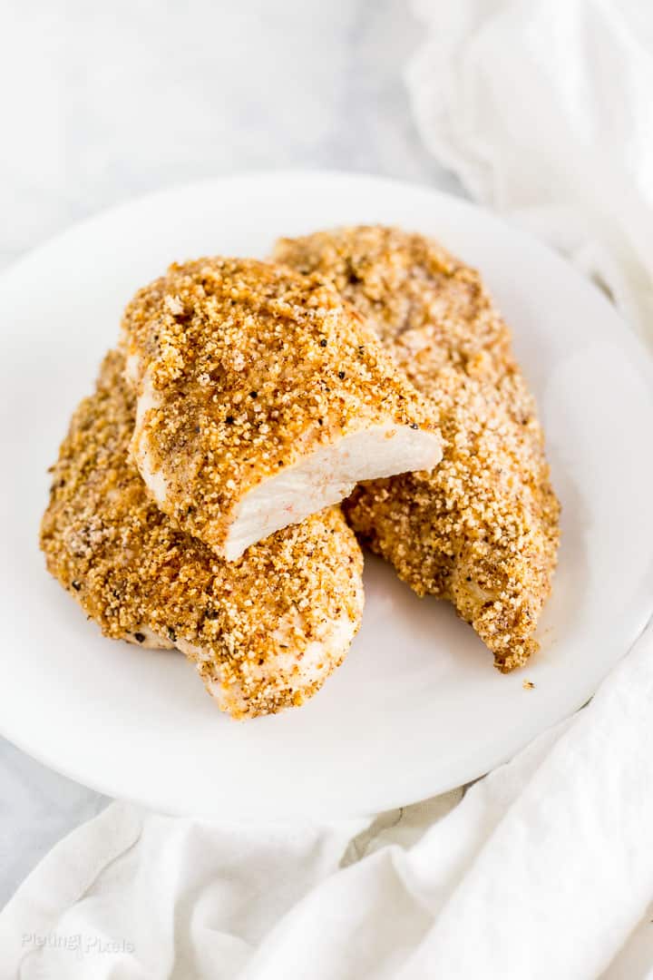 Keto Breaded Chicken Breast on a plate with a slice cut out to show moist inside