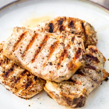 Pile of perfectly grilled pork chops resting on a plate
