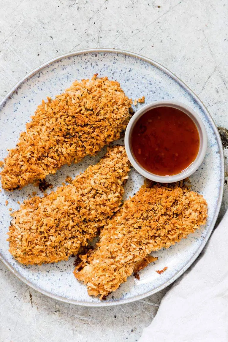 Three Parmesan Crusted Chicken Breasts on a plate next to dipping sauce