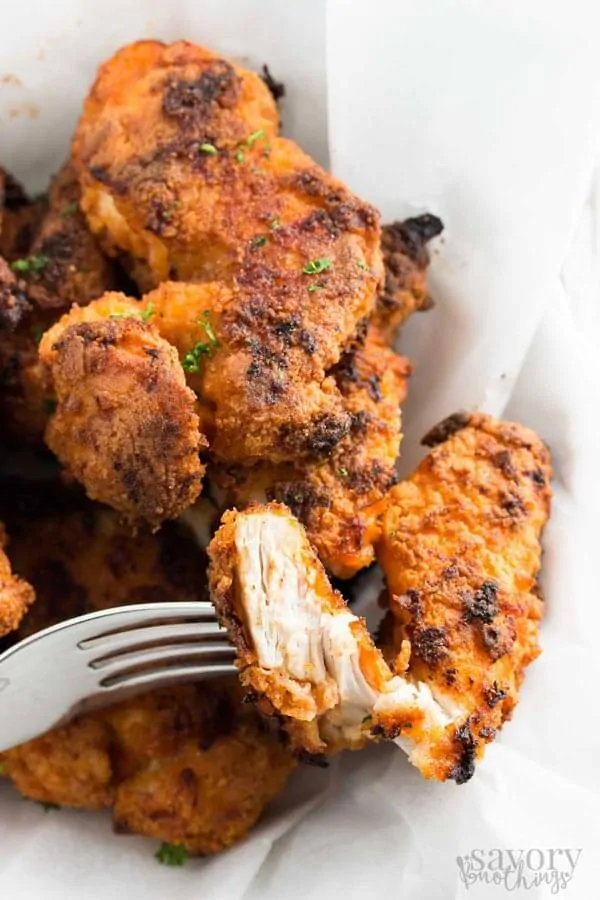 Crispy oven fried chicken with fork holding a bite