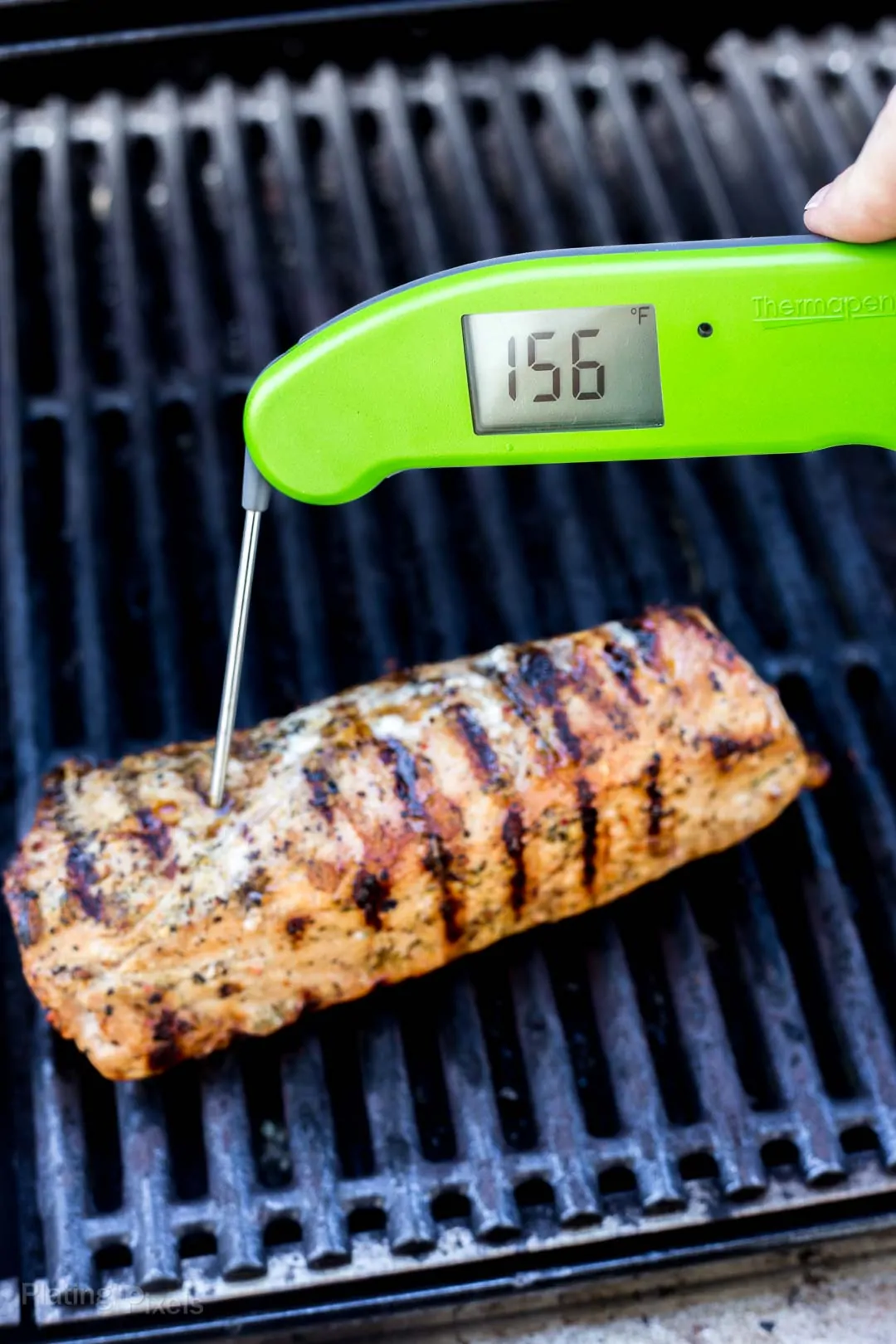 Using a digital thermometer to check internal temp of pork tenderloin