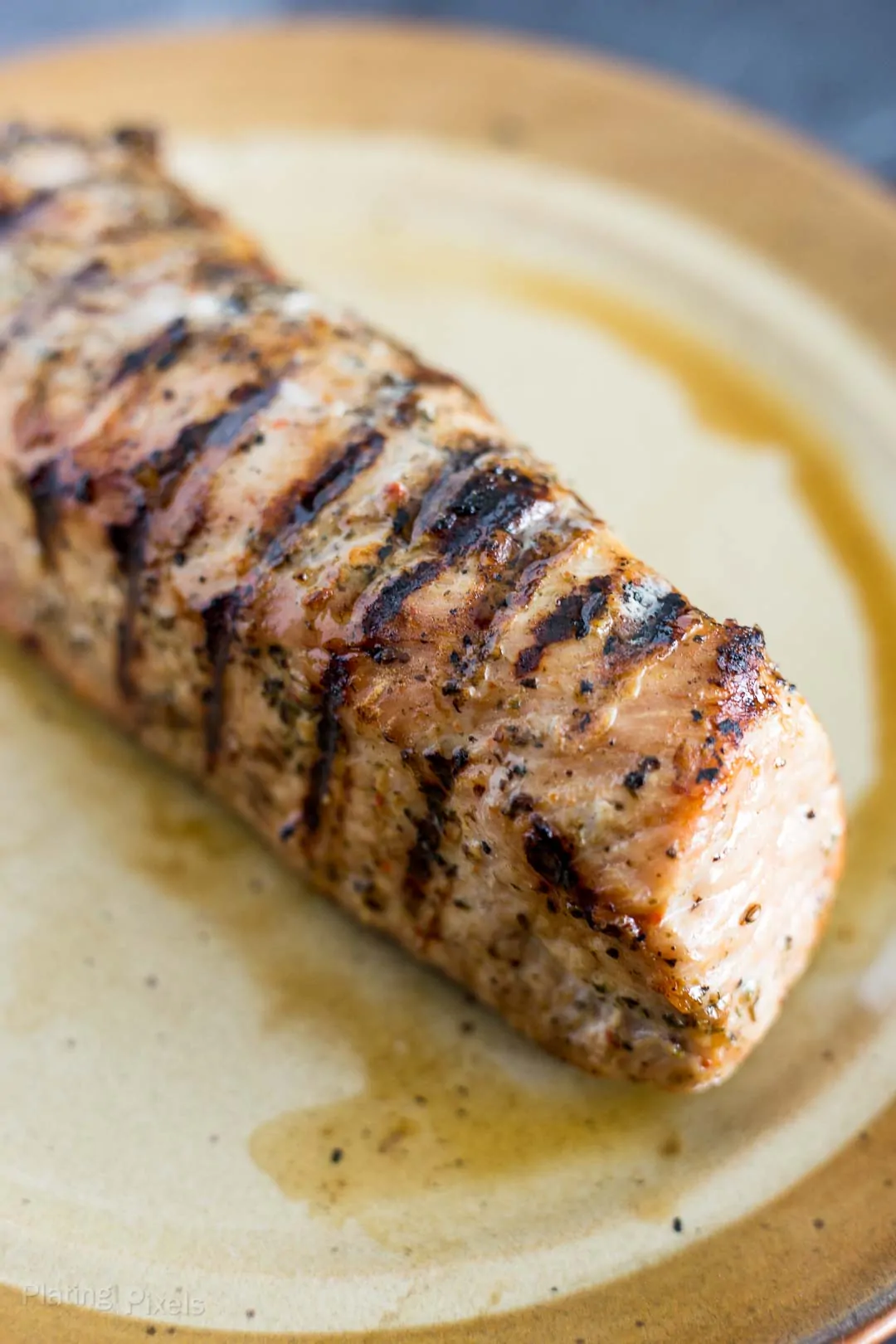 Grilled pork tenderloin resting on a plate