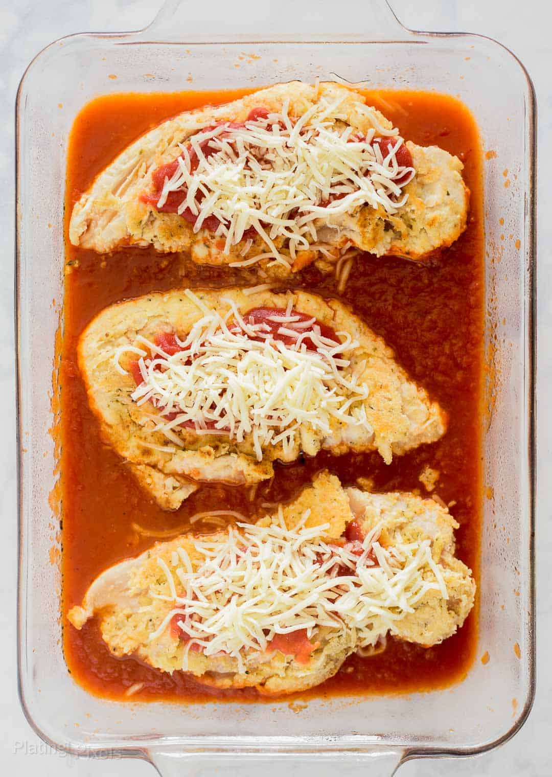 Keto Chicken Parmesan prepared in a baking dish and ready to bake