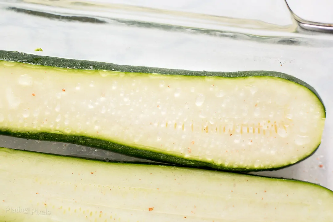 Close up of salting zucchini showing bead of water on the surface 