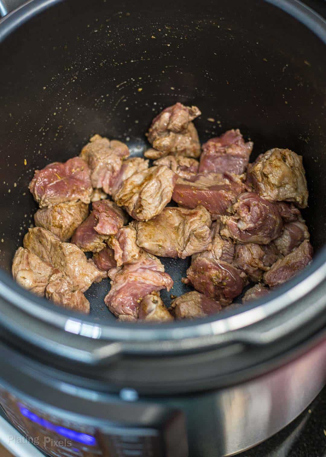 Browning pork shoulder pieces in an Instant Pot