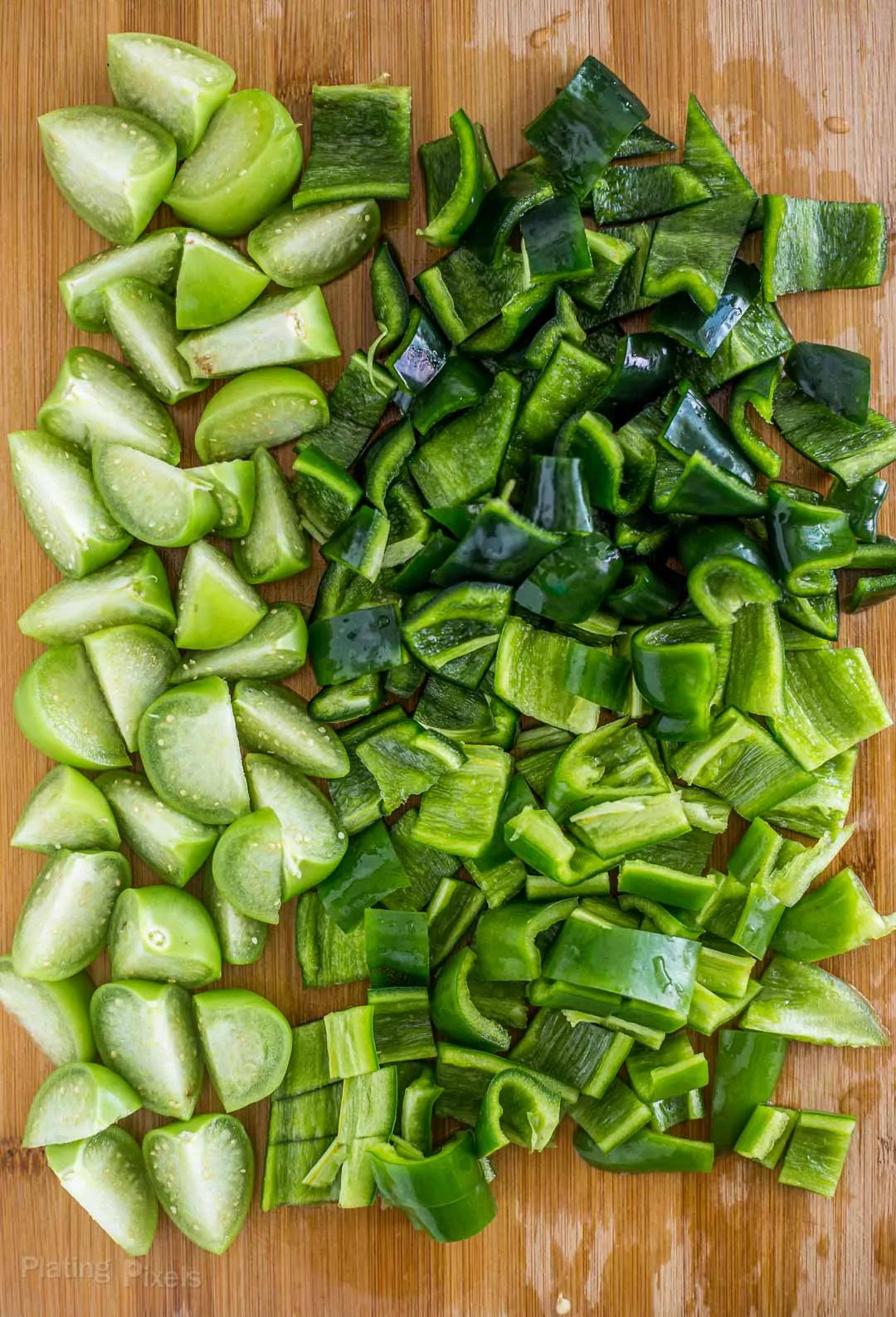 Chopped tomatillos, Poblano peppers, and Anaheim peppers to on a cutting board make Chile Verde