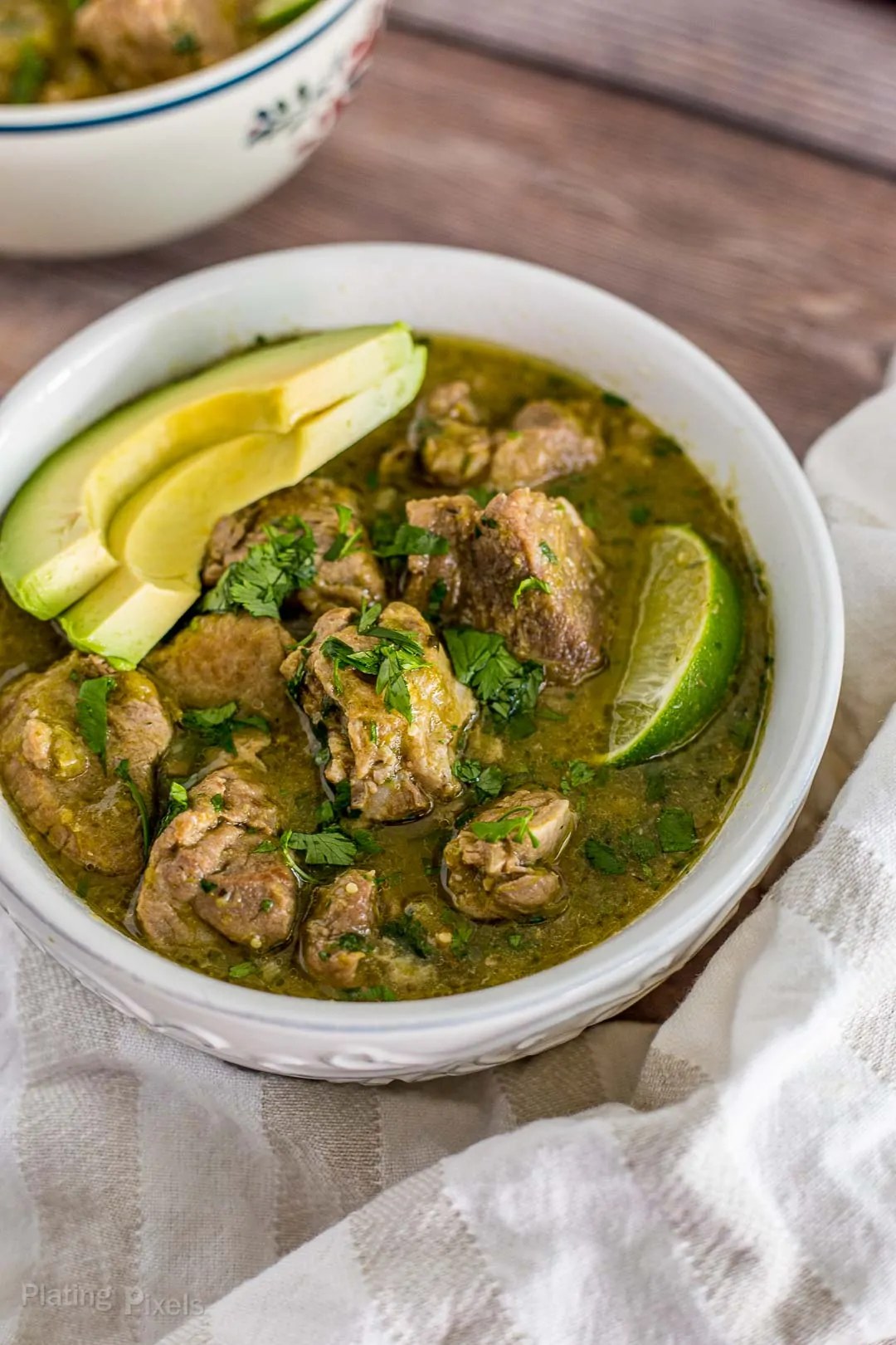 Bowl of prepared Pressure Cooker Chile Verde Pork with avocado wedges