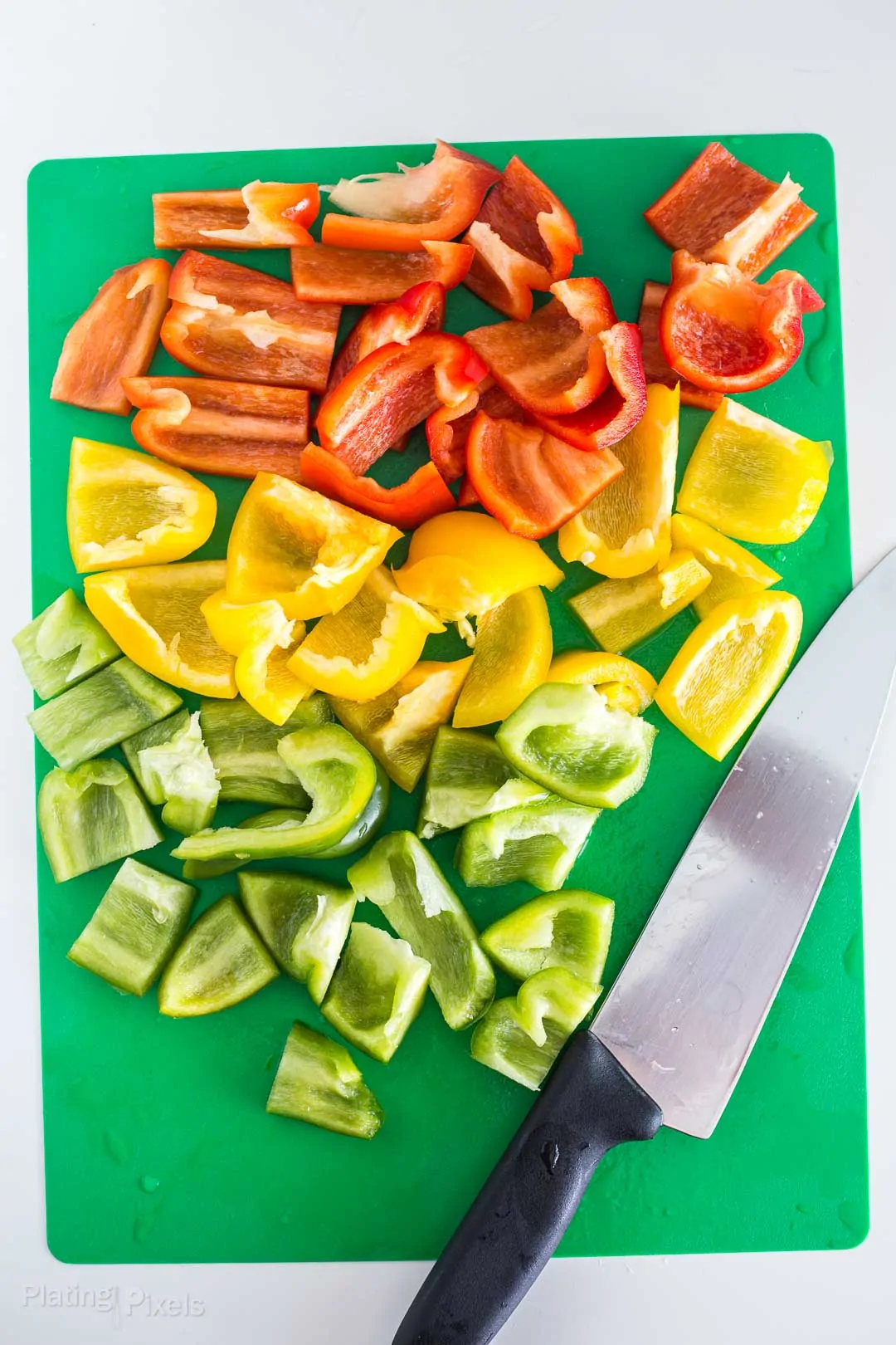 Process shot of chopped bell peppers on a cutting board