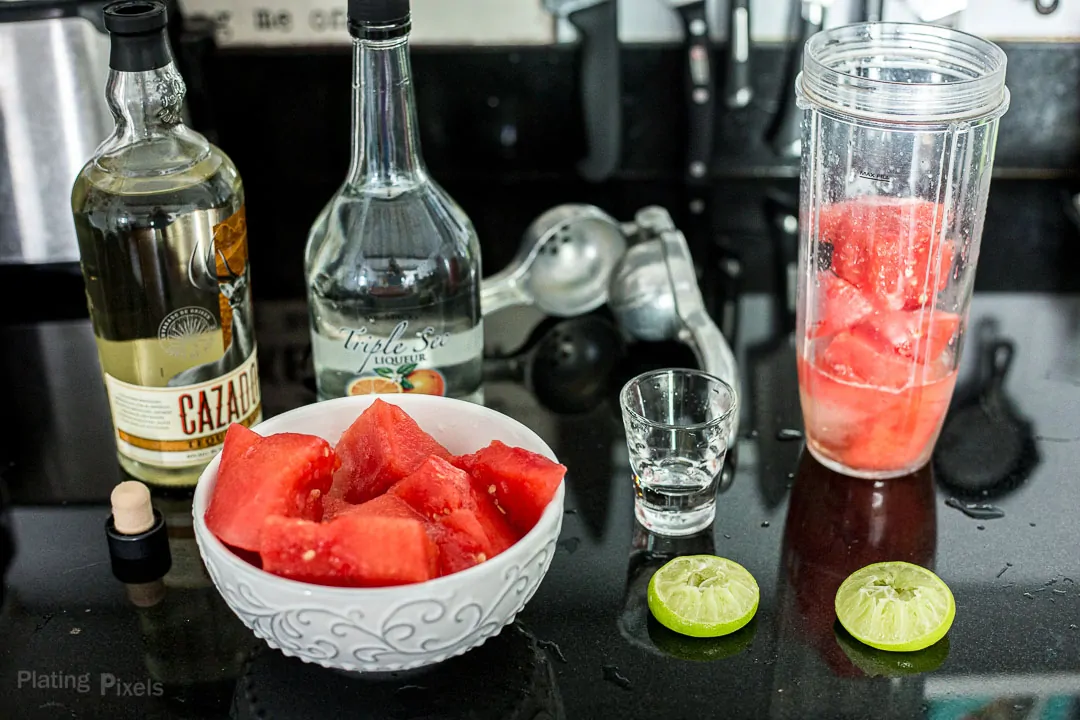 Ingredients needed to make a watermelon margarita prepped on a kitchen counter