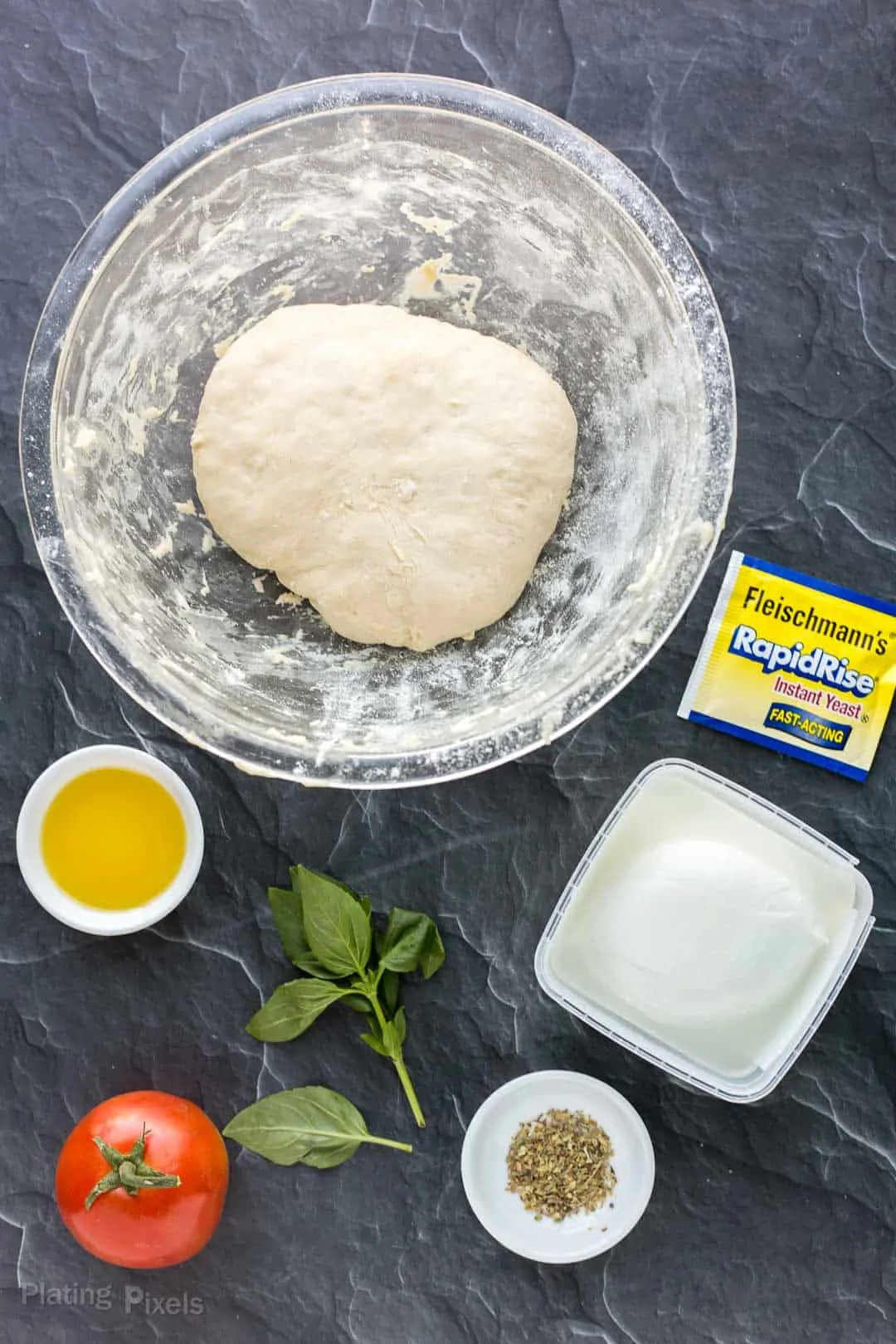 Ingredient for making Caprese pizza on a marble counter