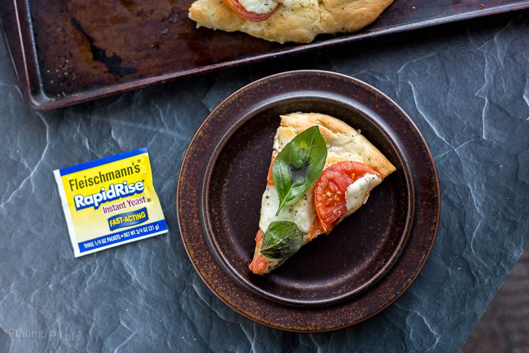 Slice of pizza next to package of rapid rise yeast