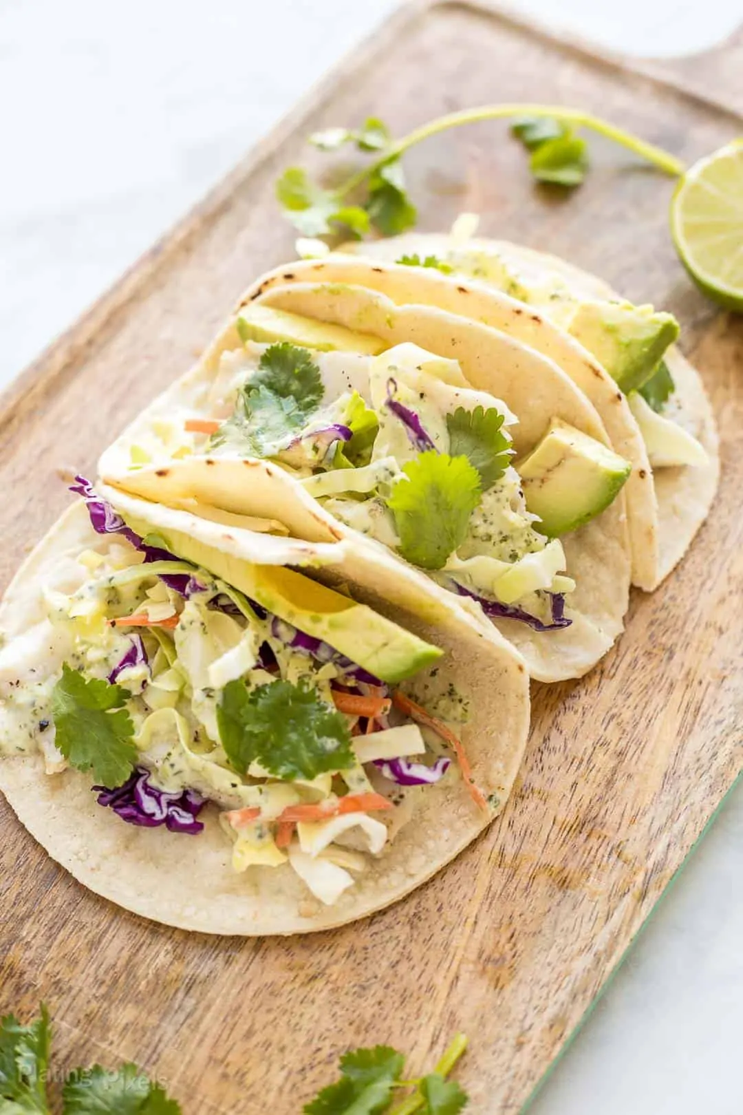 Angled shot of three Baked Fish Tacos with Cilantro Dressing