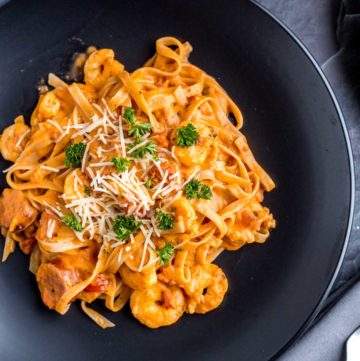 Shrimp and Sausage Spaghetti with Rosa Sauce served on a black plate