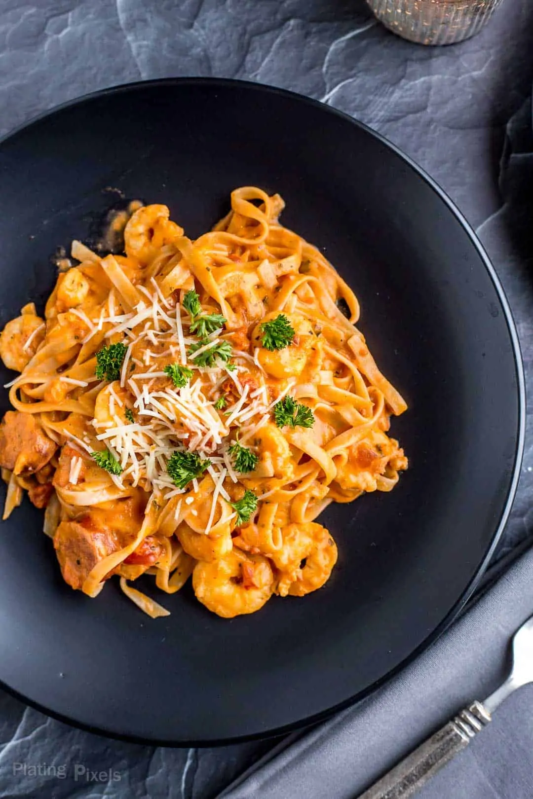 Shrimp and Sausage Spaghetti with Rosa Sauce served on a black plate