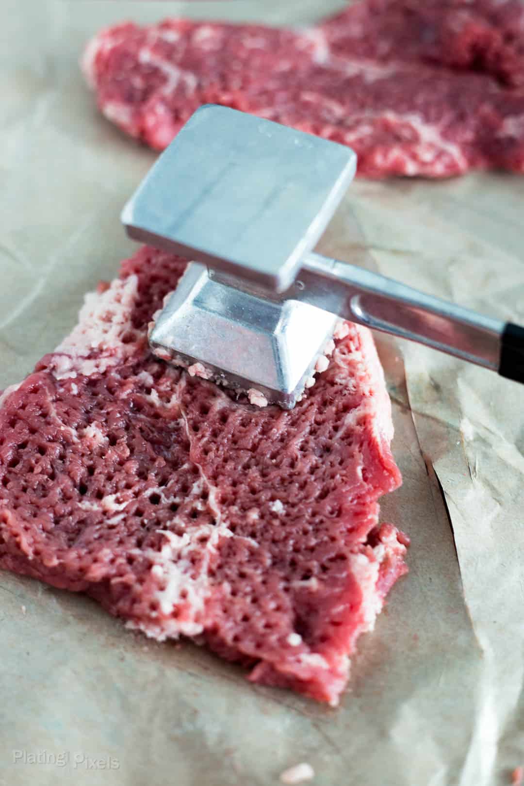 Process shot if pounding cube steak with a meat mallet