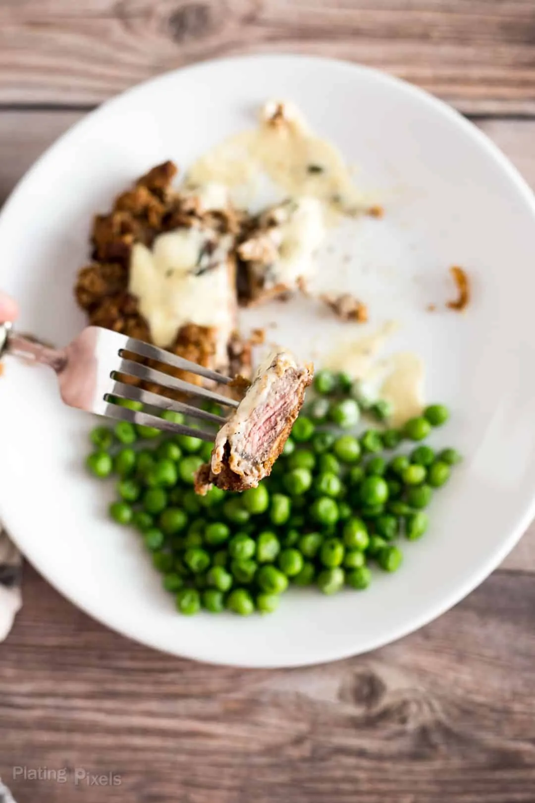 Fork holding a juicy piece of Chicken Fried Steak