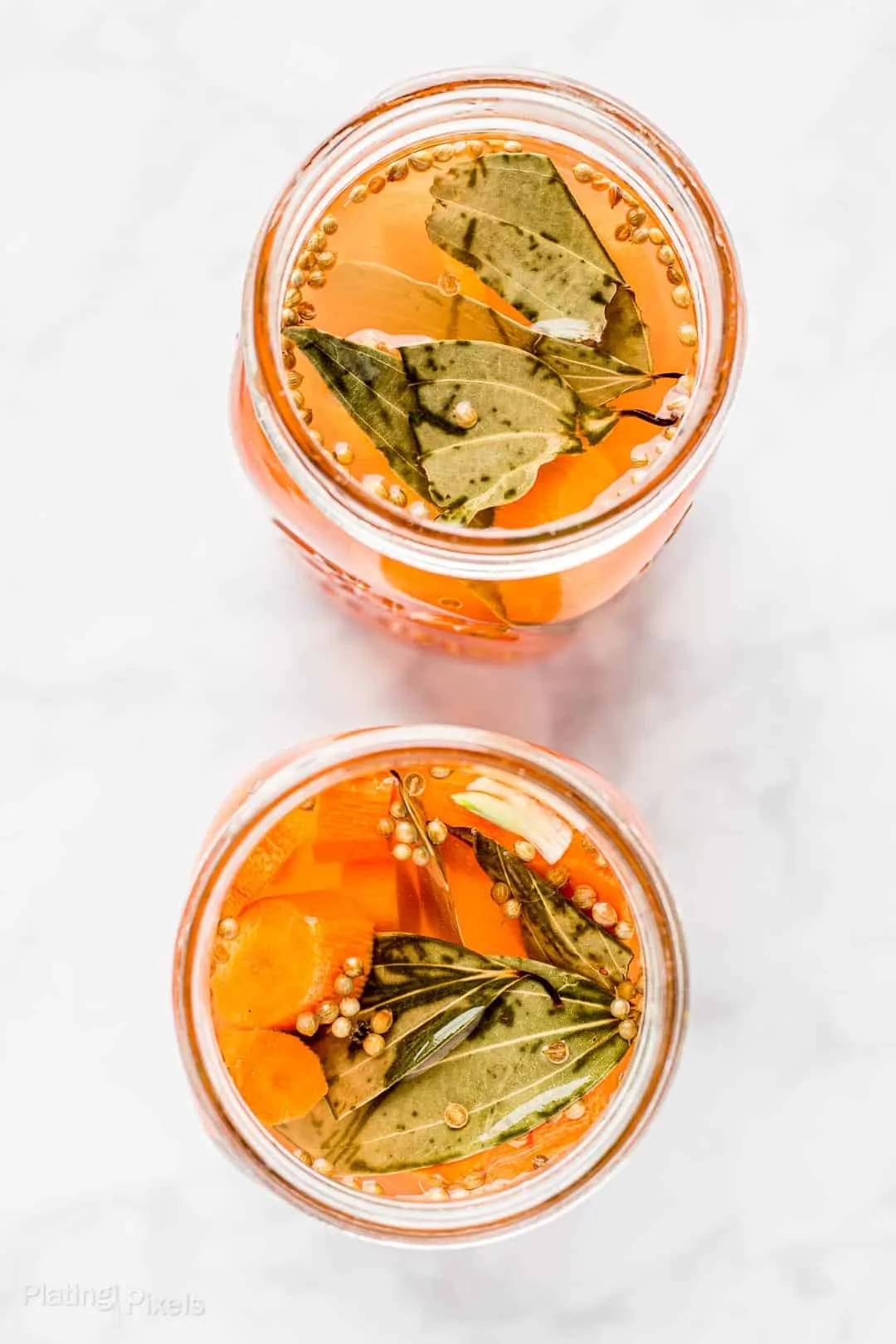 Overhead shot of two mason jars of Lacto Fermented Carrots