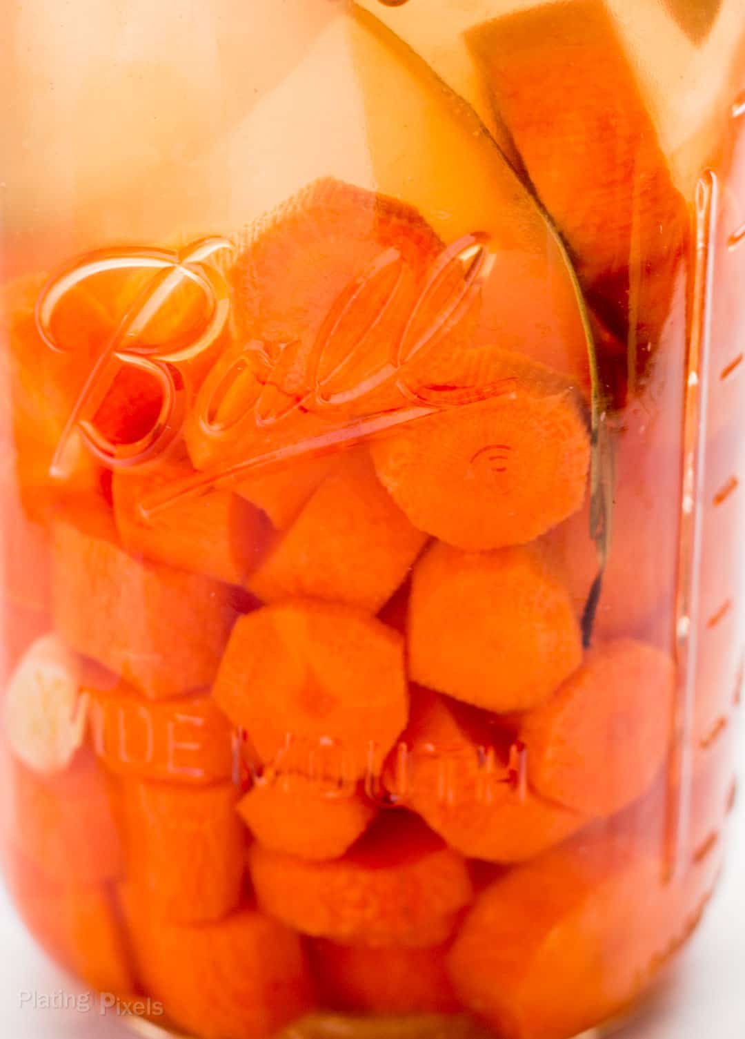 Close up of fermented carrots in a mason jar