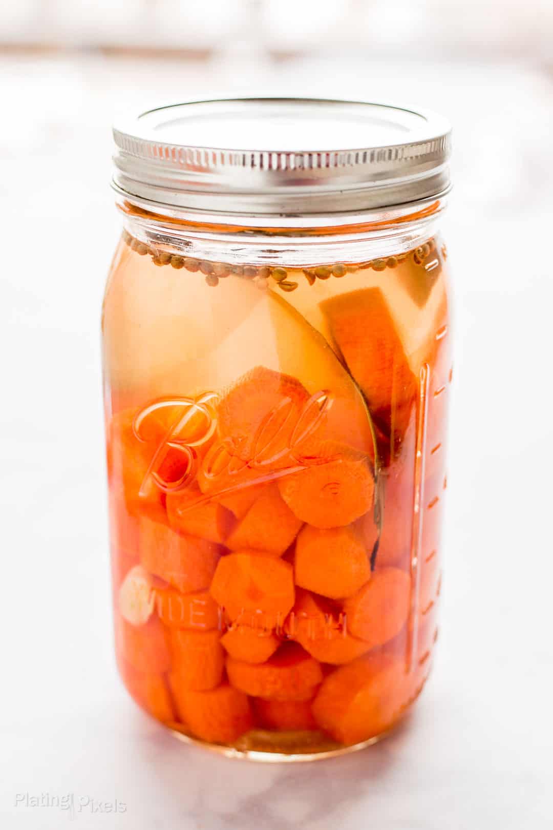 Carrots fermenting in a mason jar to make pickled carrots