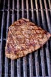 Process shot of a London Broil steak cooking on a gas grill