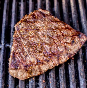 Process shot of a London Broil steak cooking on a gas grill