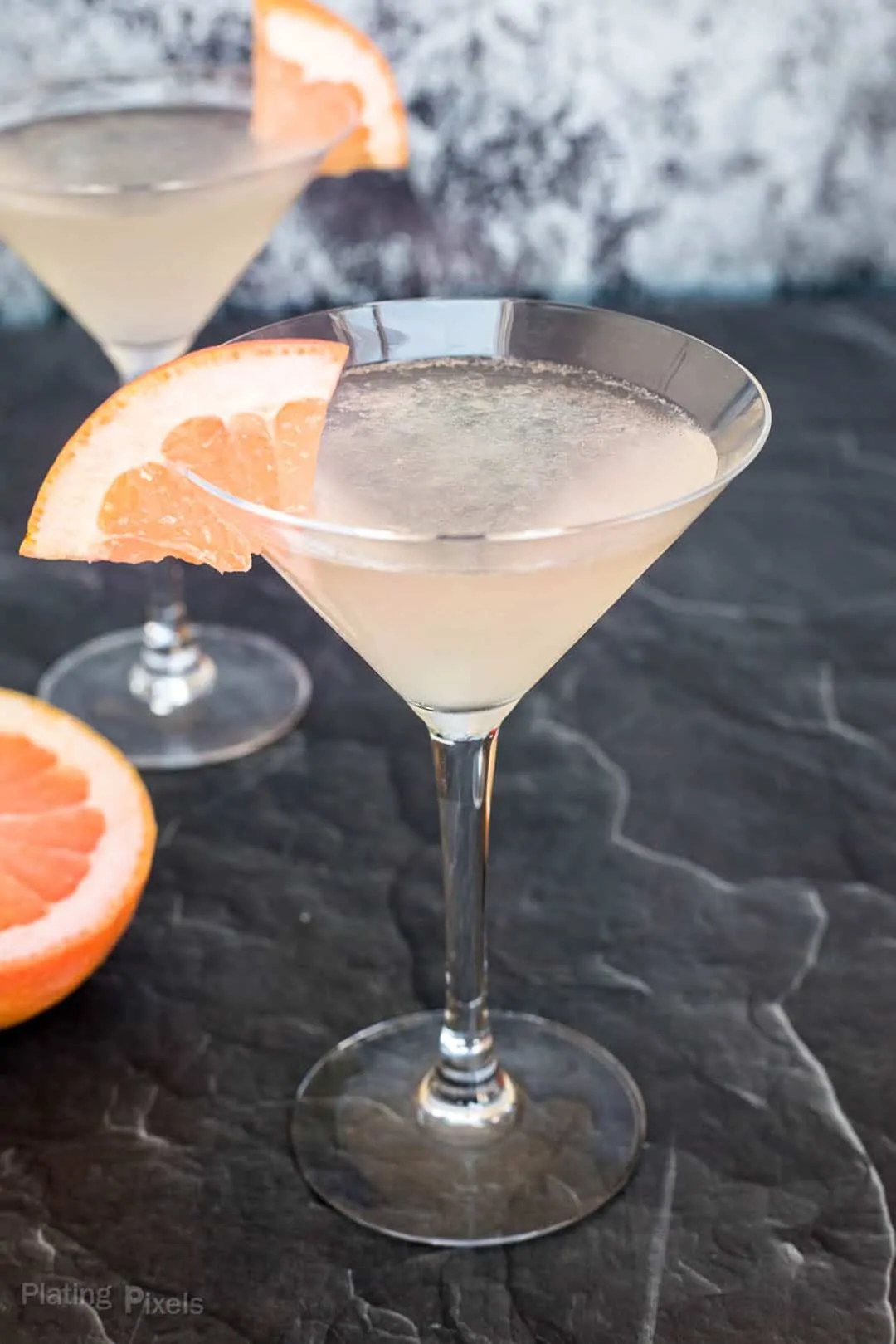 Close up a Grapefruit Martini on a black marble counter