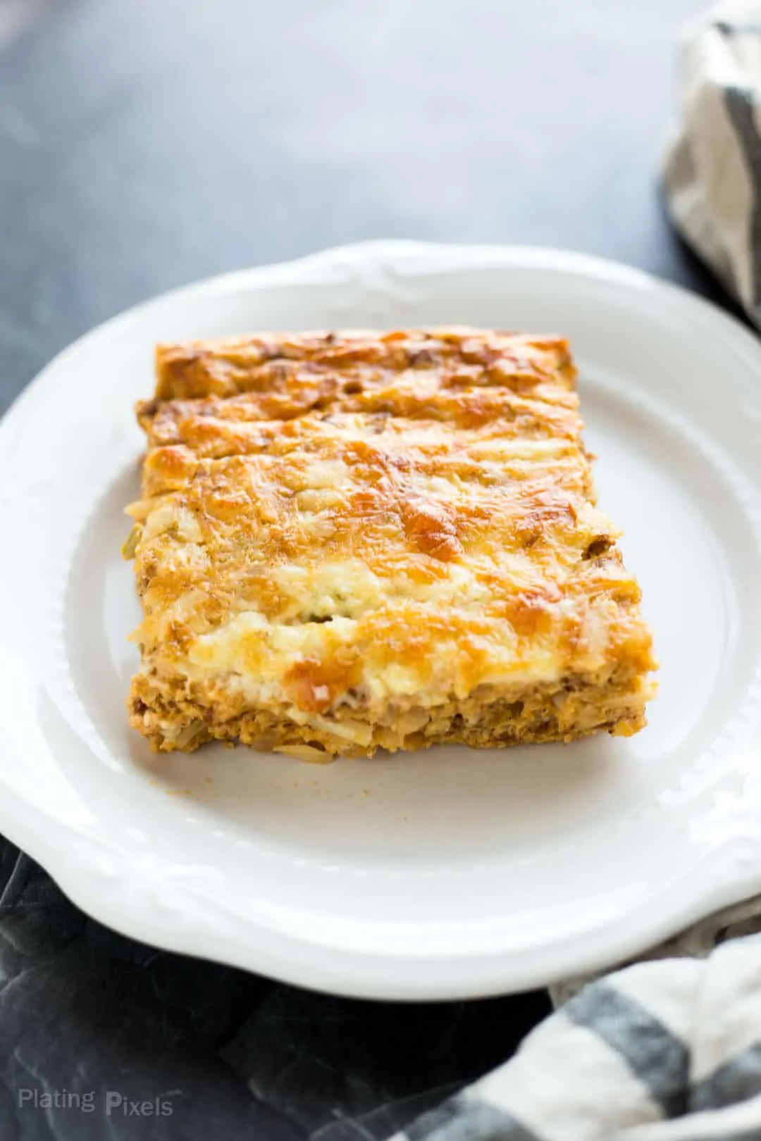 Cut square of a Hash Brown Breakfast Casserole on a plate