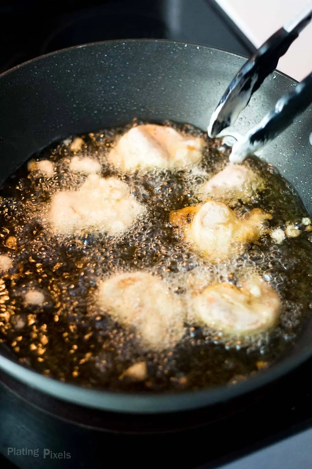 Process shot of frying fish in a pan