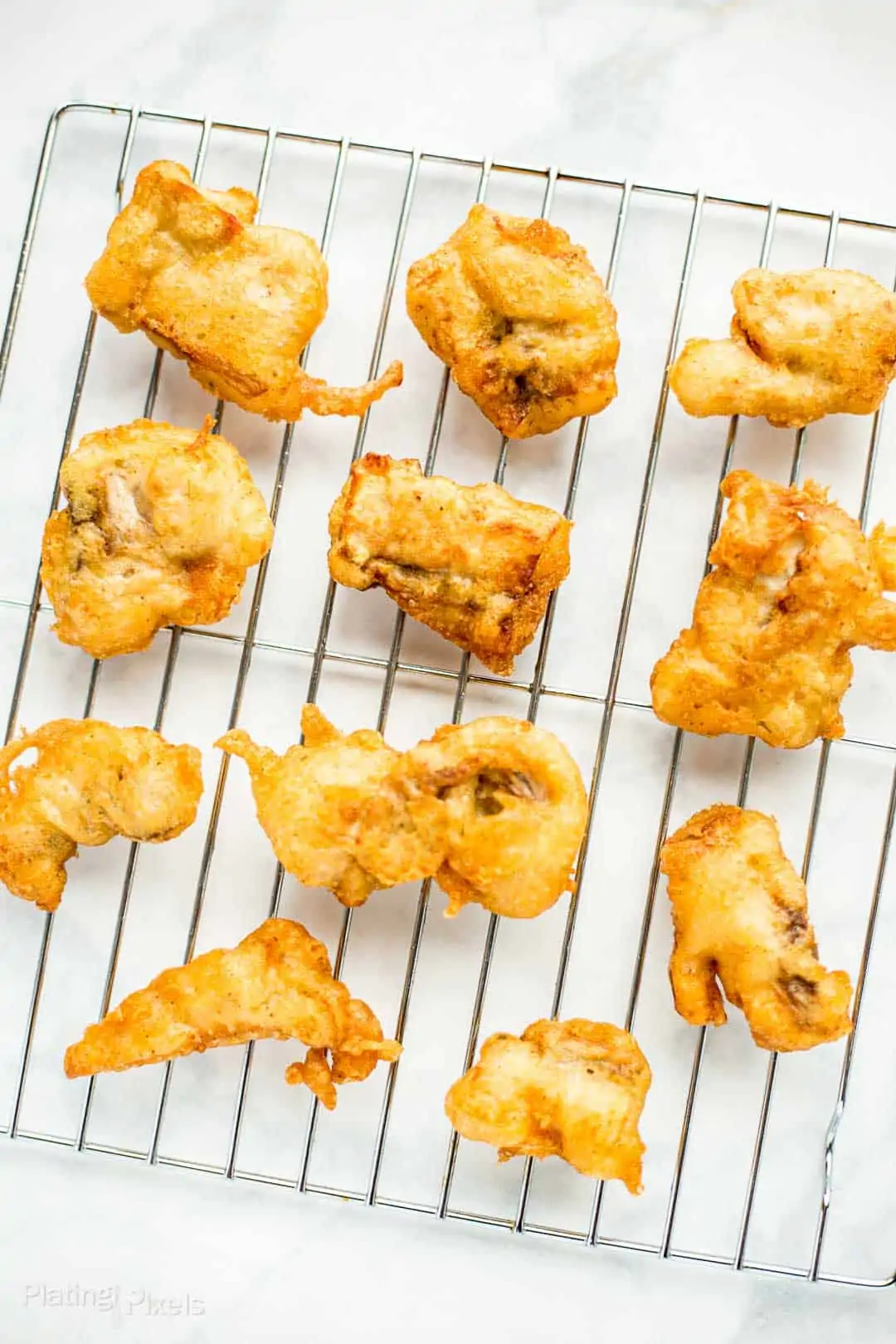 Golden Beer Battered Fried Fish pieces on a wire rack