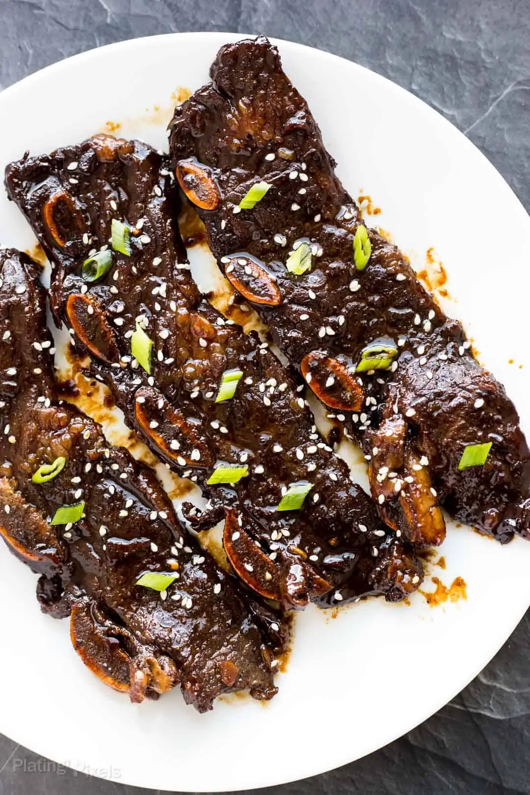 Three Kalbi Korean Short Ribs served on a white plate